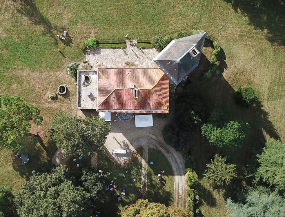 Photo vue du ciel du château et de sa tour pentagonale, avec son jardin et une partie de son parc